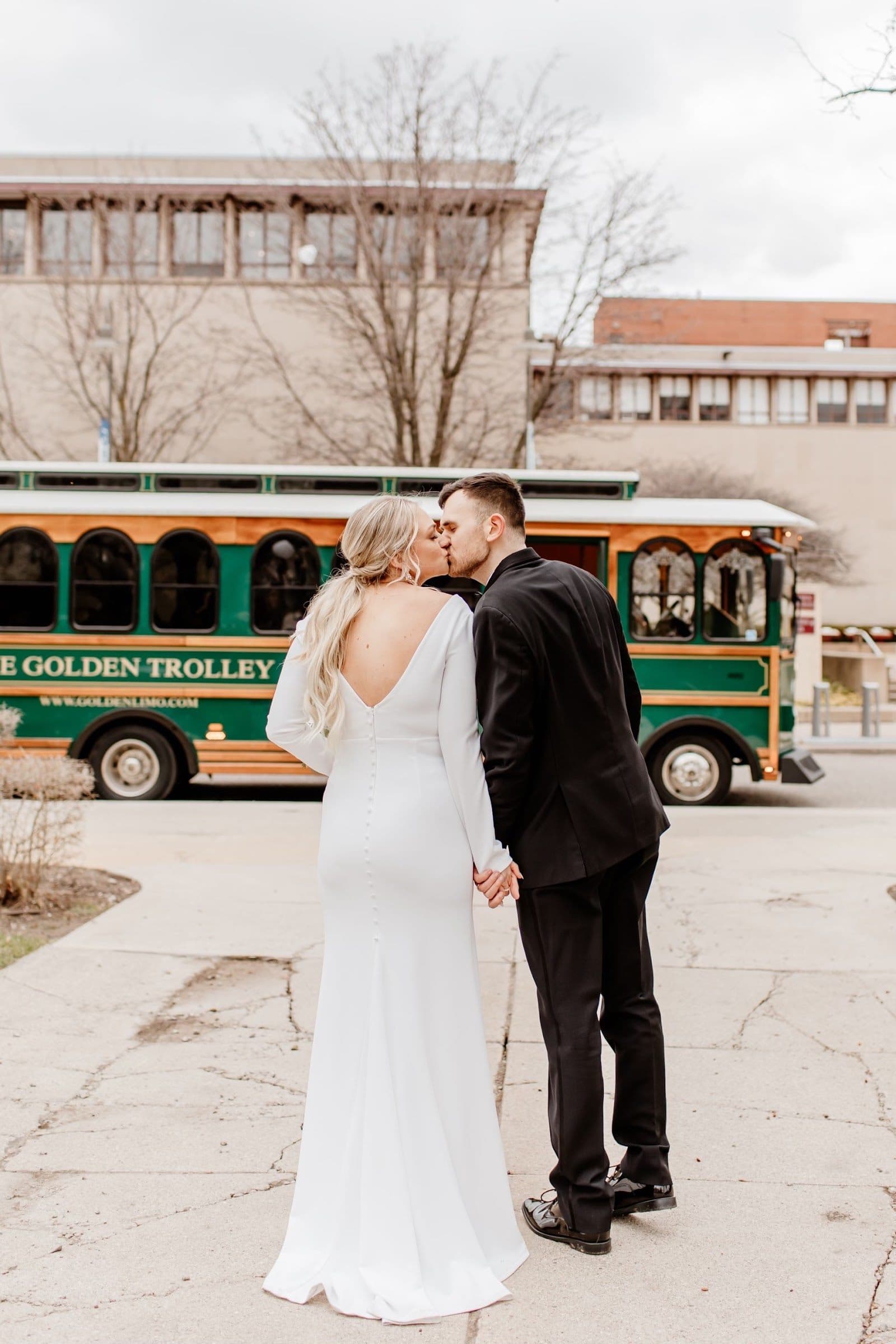Bride and groom sharing a kiss in front of the Golden Trolley