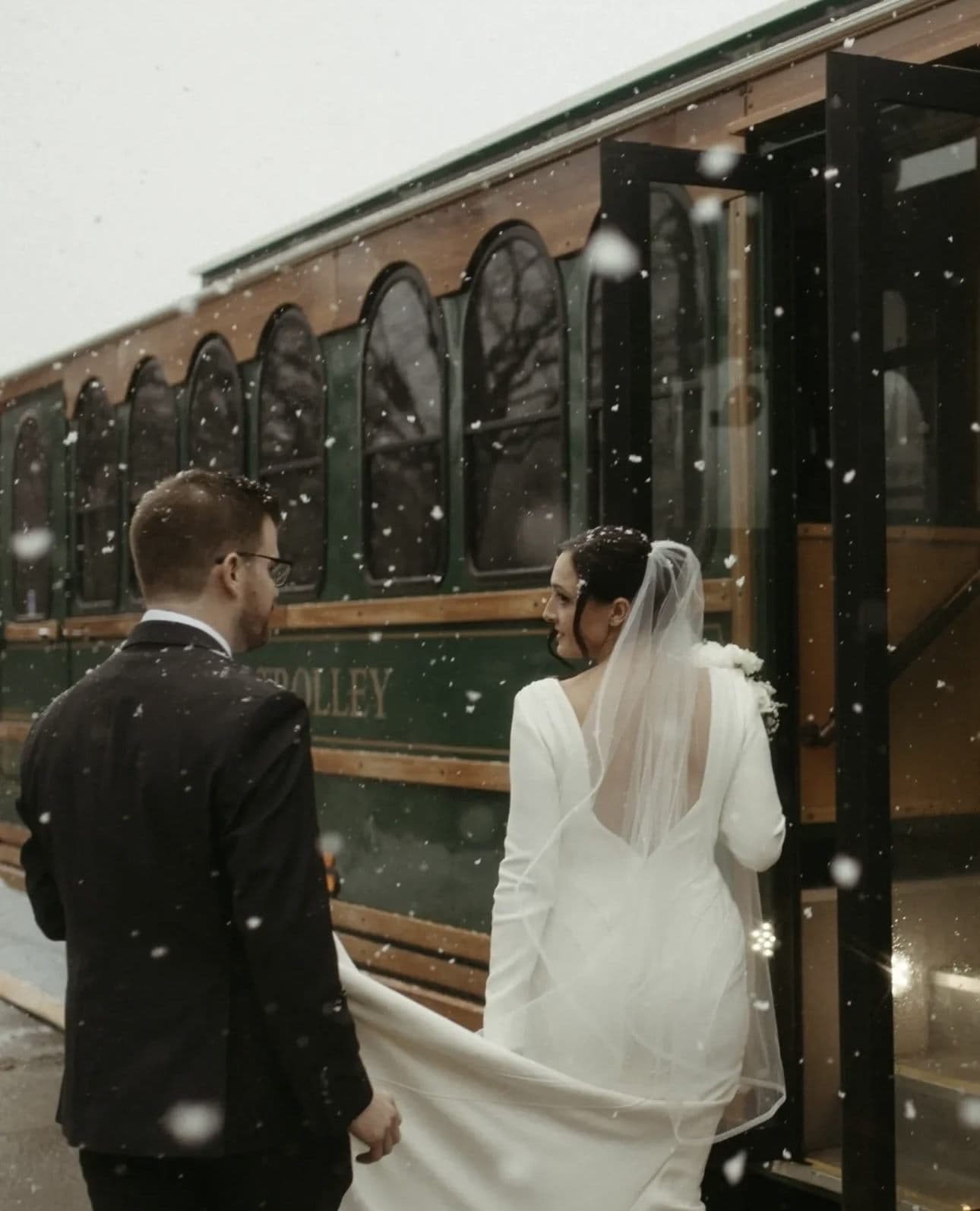 Couple by the trolley window during a winter wedding