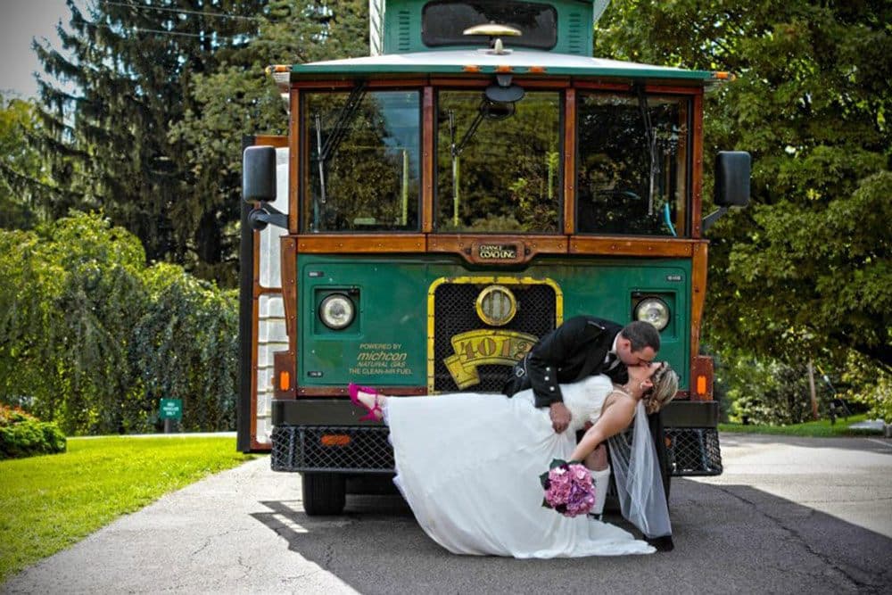 Groom dipping the bride for a kiss beside the trolley