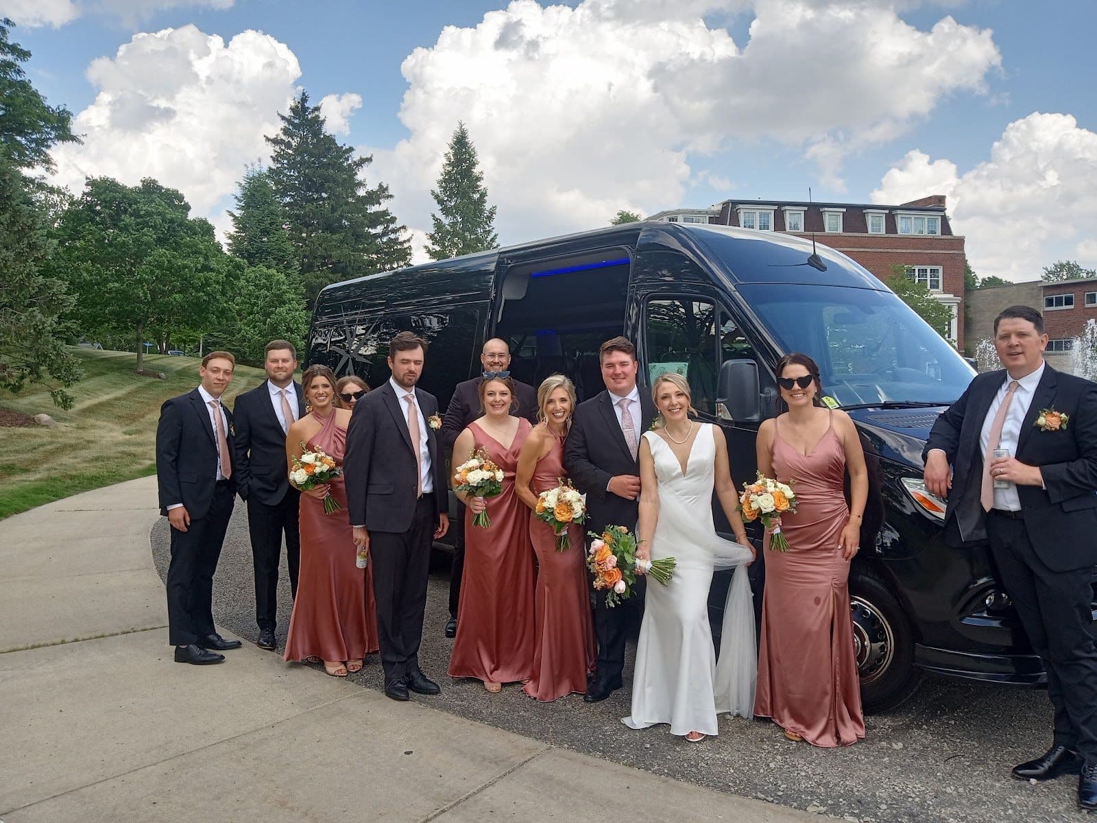 Full wedding party posing with a Golden motorcoach